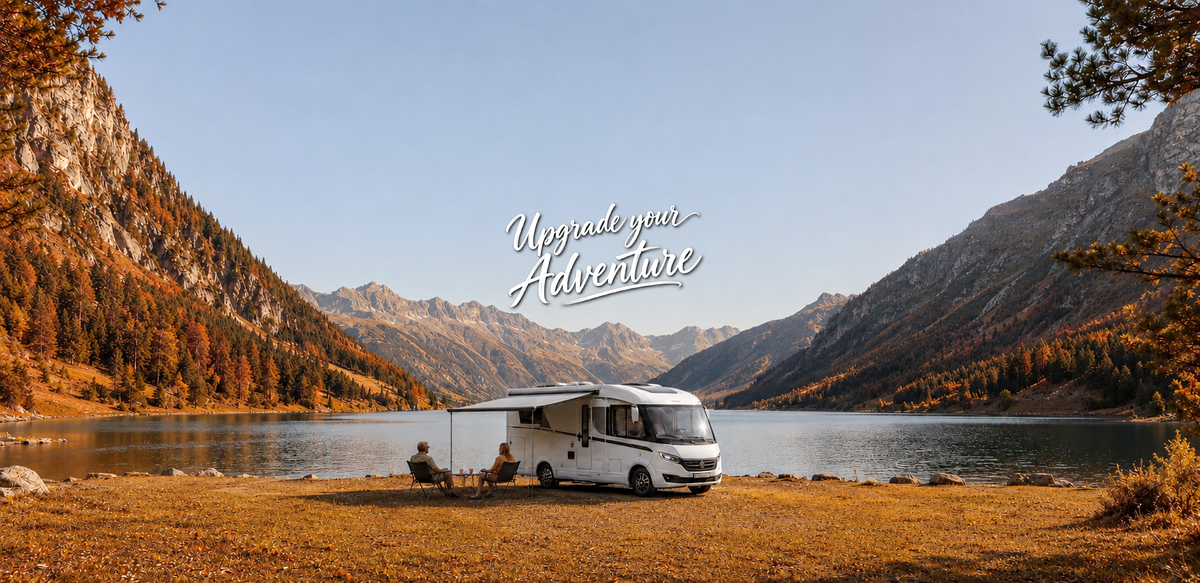 Motorhome parked by a lake with autumn trees and mountains